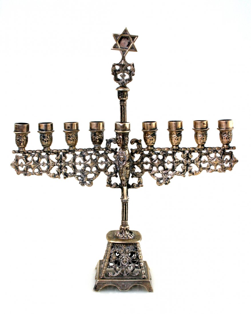 A SILVER CHANUKAH MENORAH. The Netherlands, c. 1900: A SILVER CHANUKAH MENORAH. The Netherlands, c. 1900. Cast, with figural decorations. Marked. 8.2" tall.