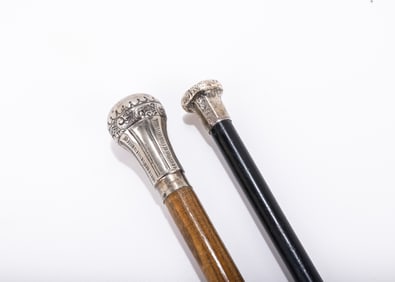 A GROUP OF TWO STERLING SILVER HANDLED DRESS CANES. London, c. 1900. Traditional grip model.&nbsp;