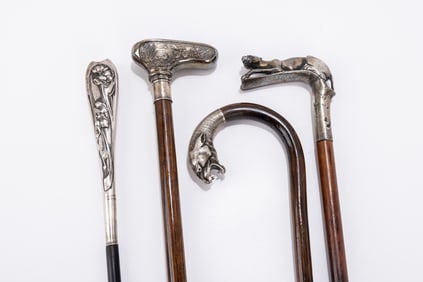 FOUR SILVER HANDLED DRESS CANES. Various origins and ages. Including a greyhound dog, a leopard and