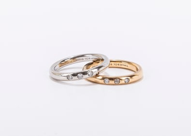 ONE PLATINUM AND ONE 18K YELLOW GOLD TIFFANY AND COMPANY THREE STONE FULL CUT DIAMOND BAND. Each
