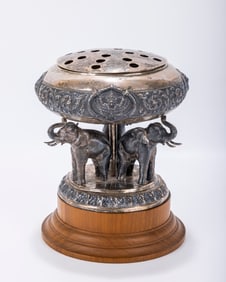 A LARGE SILVER AND WOOD FIGURAL INCENSE BURNER. India, c. 1900. On a wood base with three elephants