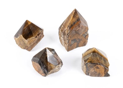 A GROUP OF FOUR CRYSTAL CUT FORM TIGER’S EYE STONE.