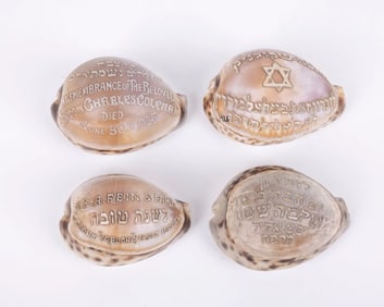 A GROUP OF FOUR HAND CARVED JUDAIC COWRY SHELLS