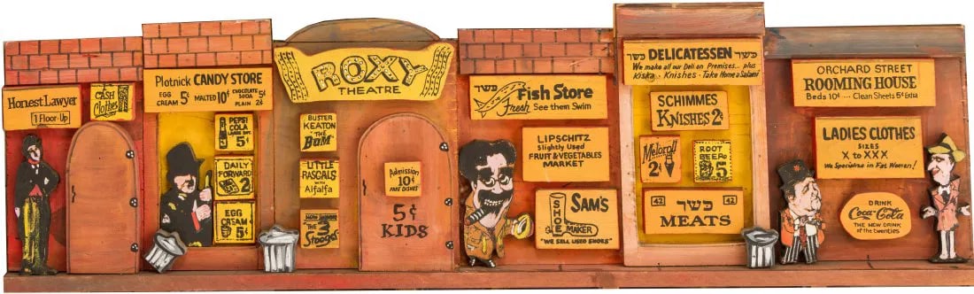 A LARGE “LOWER EAST SIDE” WOODEN SCULPTURE BY HARRY GLAUBACH (1925-2017): Highly decorative sculpture of the old Lower East Side envisioned by master folk artist Harry Glaubach. 48” wide.