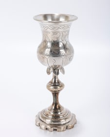 A SILVER KIDDUSH GOBLET. Vilna, 1879. On a stylized base with knobbed stem and skirted decoration.