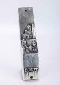 A STERLING SILVER MEZUZAH BY HENRYK WINOGRAD CASE. New Â  York, c. 1988. Depicting the Old City of