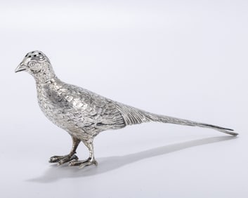 A SILVER BIRD SHAPED TABLE ORNAMENT OR SPICE CONTAINER. On two clawed feet. With a removable head