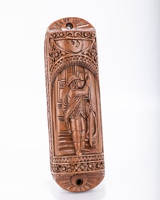 A HAND CARVED WOODEN MEZUZAH. Probably American, modern. Hand carved with a scene of a young man