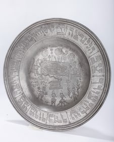 A LARGE PEWTER SEDER TRAY. Germany, 1808. The center is engraved with a seder scene at the table.