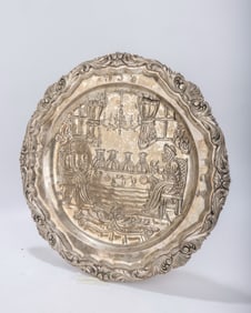 A LARGE SILVER PASSOVER PLATE. Germany, 20th century. Lated embossed with a Seder scene.