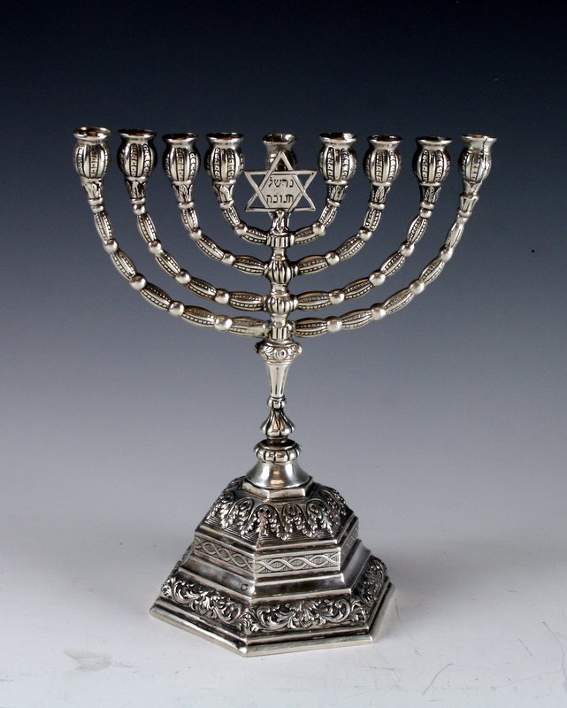 A SILVER MENORAH. Germany, c. 1880. On ornately decorat: A SILVER MENORAH. Germany, c. 1880. On ornately decorated octagonal base. With Temple style upper portion topped by a Magen David on which is inscribed: Ner Shel Chanukah. Marked 800, crown and moon. 