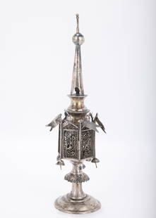 A SILVER FILIGREE SPICE CONTAINER. Poland, c. 1940. On a round base with a skirted stem. Fitted with: A SILVER FILIGREE SPICE CONTAINER. Poland, c. 1940. On a round base with a skirted stem. Fitted with six flags and six bells along the eight sided body. Marked 12. 10" tall. Lacking an upper flag.