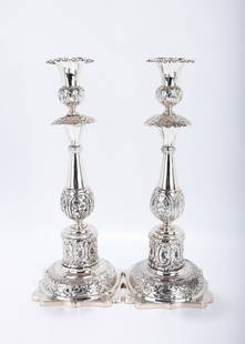 A PAIR OF EXCEPTIONAL SILVER SABBATH CANDLESTICKS Minsk, 1880. Each on a stylized square base,: A PAIR OF EXCEPTIONAL SILVER SABBATH CANDLESTICKS Minsk, 1880. Each on a stylized square base, chased with organic designs. The stem is baluster shaped and further embossed with floral designs. Fitted