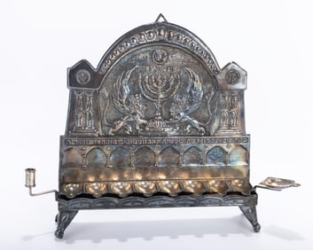 A CHANUKAH LAMP BY BEZALEL. British Mandate Palestine, c. 1925. The back plate chased with two
