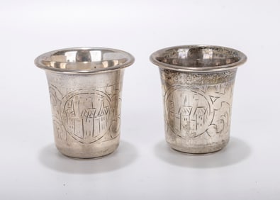 A PAIR OF SILVER KIDDUSH CUPS. Warsaw, c. 1880. Each in beaker form with engravings of city scenes.