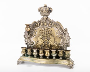 A BRASS HANUKKAH LAMP. Warsaw,  c.1880. On four legs. Decorated with scrolls, lions, a Temple style