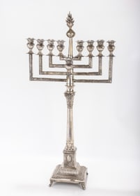A LARGE SILVER MENORAH. Warsaw, c.1900. On an ornately decorated base in candlestick form. With a