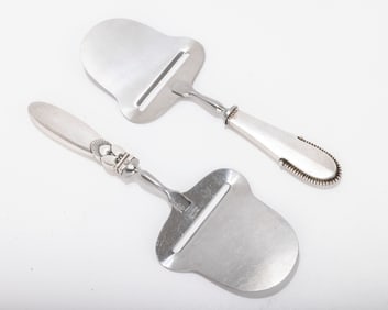 TWO STERLING SILVER HANDLED CHEESE SLICERS BY GEORGE JENSEN. Denmark, mid-century. Each in a