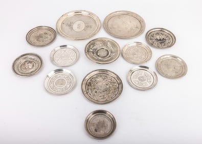 A GROUP OF 13 SILVER UNDERPLATES FOR WINE CUPS. Russian and Polish, c. 1900. Each is engraved in a