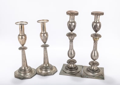 TWO PAIRS OF SILVER SABBATH CANDLESTICKS. Poland, c. 1860. Each with a flat base, skirted stems and