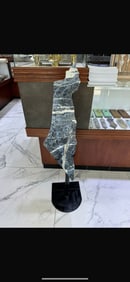 A SODALITE CARVED INTO THE SHAPE OF THE STATE OF ISRAEL ON A STAND