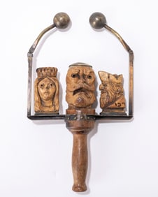 8. A HAND CARVED GRAGGER. Probably American, 20th century. With two swinging brass spheres that