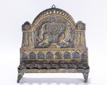 37. A SILVER PLATED HANUKKAH LAMP BY THE BEZALEL SCHOOL. Jerusalem, c. 1920. On four feet with eight