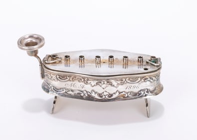 48. A TRAVELLING SILVER HANUKKAH LAMP. Oblong form. Formed from a tobacco box. With the original