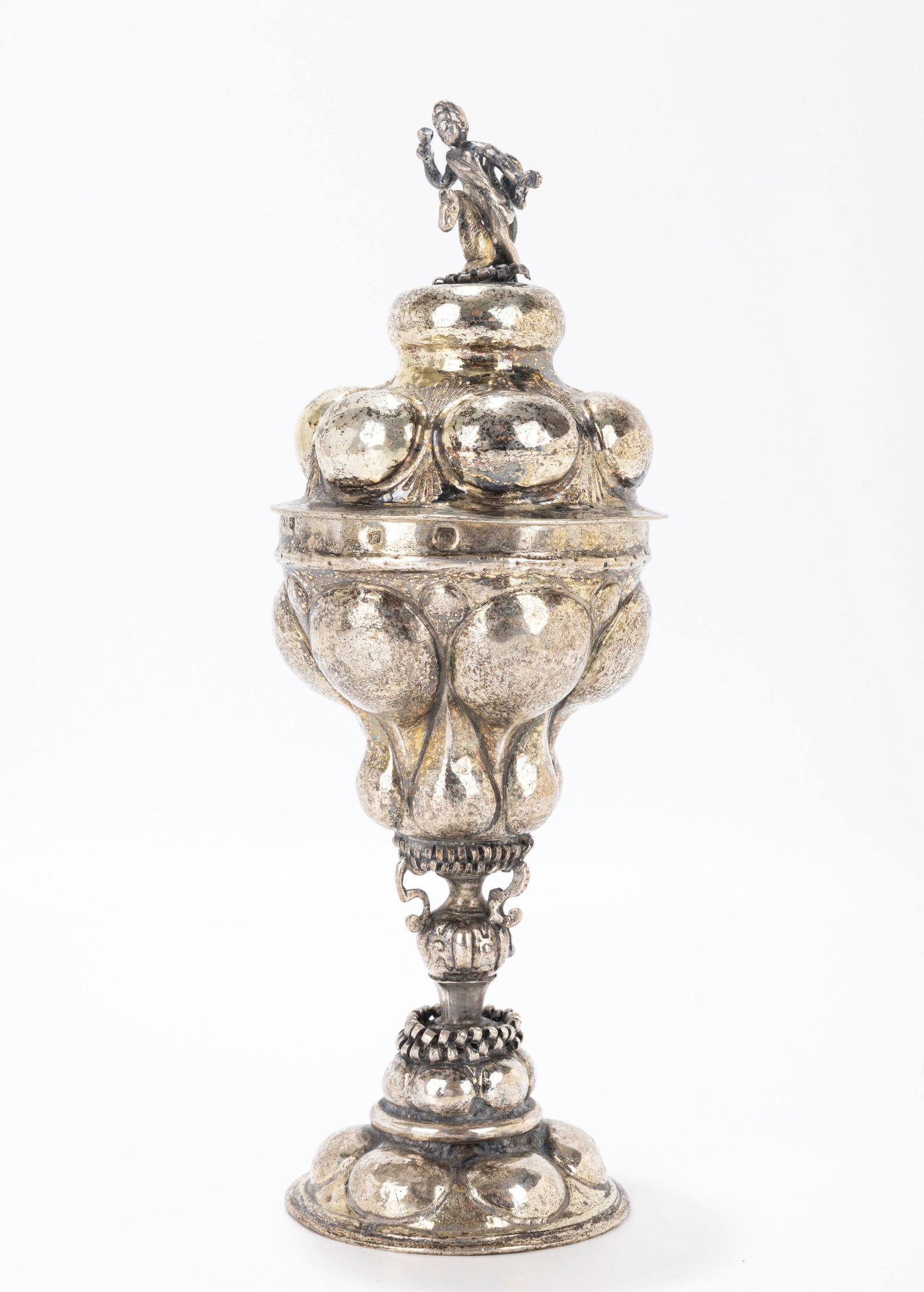 65. AN EARLY COVERED SILVER GOBLET. Nuremberg, 18th century. On a domed handchased base with an: 65. AN EARLY COVERED SILVER GOBLET. Nuremberg, 18th century. On a domed handchased base with an outwardly tapering upper portion Topped with a cherub on a horse finial. 8.2" tall.