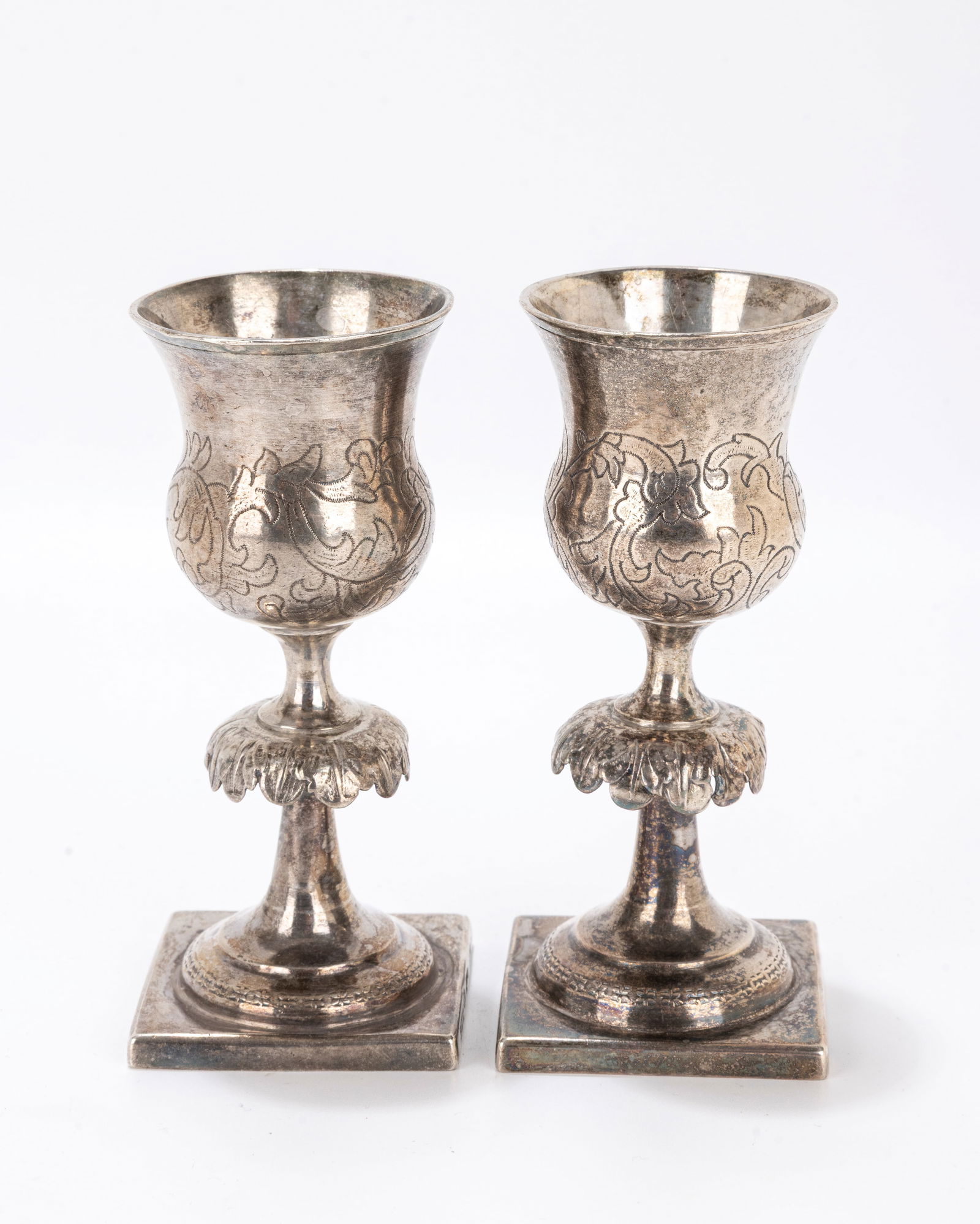91. A PAIR OF SILVER KIDDUSH GOBLETS. Warsaw, 1867. Each on a square base with a large skirted (1 of 9)