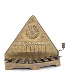108. A BRASS HANUKKAH LAMP BY THE BEZALEL SCHOOL. Palestine, c. 1920 Triangular form Decorated with