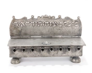 112. A PEWTER HANNUKAH LAMP. In German style. Bench form. Embossed with Hanukkah related epithets.