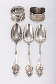 194. THREE ANTIQUE STERLING SILVER MEDALLION SPOONS AND TWO NAPKIN RINGS. The spoons by Gorham are