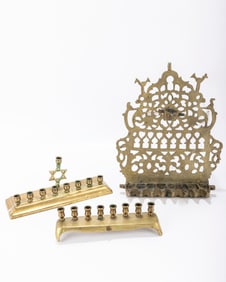 213. THREE BRASS HANUKKAH LAMPS. The first in Moroccan style. The last two for candles.