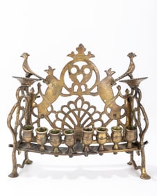 220. A BRASS CHANUKAH LAMP. Poland or Ukraine, 19th century. On four feet. With a back plate