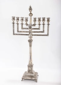 A LARGE SILVER MENORAH. Warsaw, c.1900. On an ornately decorated base in candlestick form. With a la