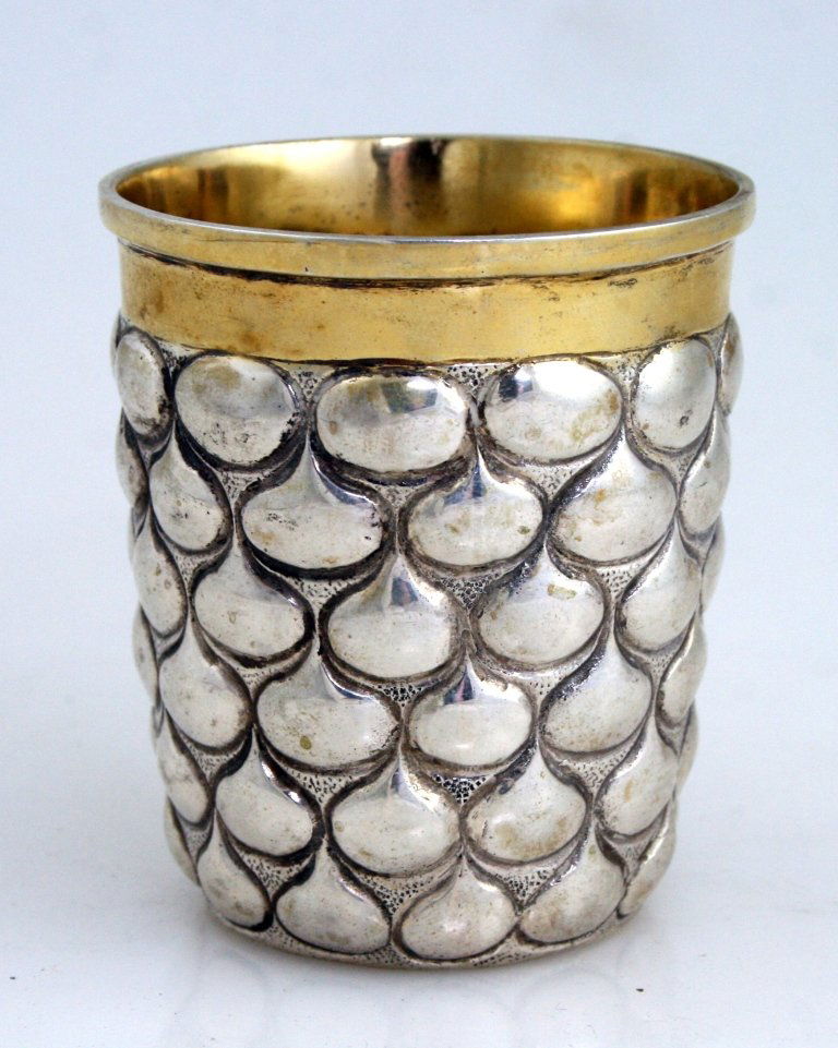 A SMALL PARCEL GILT SILVER BEAKER. Germany, c. 1880. Ha: A SMALL PARCEL GILT SILVER BEAKER. Germany, c. 1880. Hand chased with tear drop designs. Marked 800, crown and moon. 2.7” tall. Estimate $300 – 600
