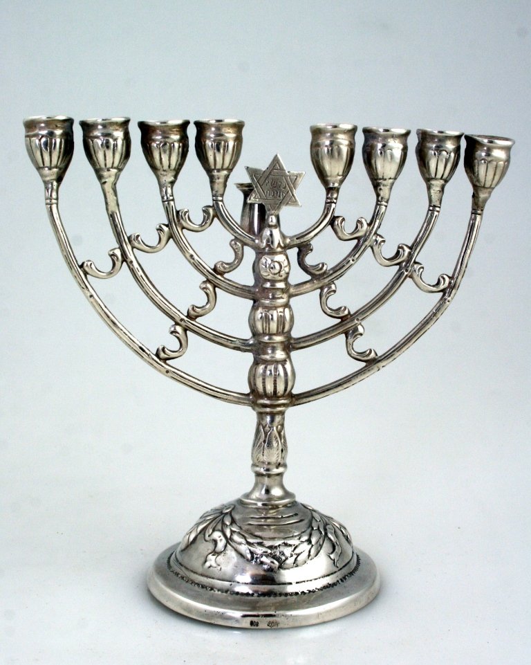 A SILVER CHANUKAH MENORAH. Germany, c. 1900. On round b: A SILVER CHANUKAH MENORAH. Germany, c. 1900. On round base with eight stems and a servant lamp. Marked 800, crown and moon. 5.2” tall. Estimate $600 – 900
