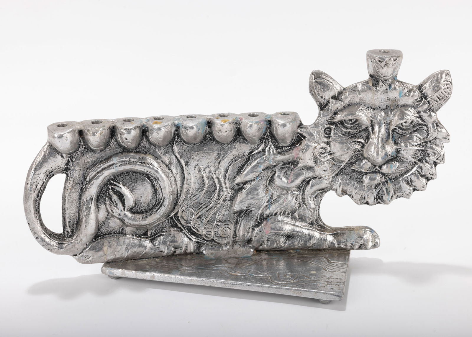 A LARGE ALUMINUM MENORAH SCULPTURE BY DON DRUMM (American, b. 1935).: A LARGE ALUMINUM MENORAH SCULPTURE BY DON DRUMM (American, b. 1935). With a cat design, on a rectangular base. Signed. 15 inches wide. Estimate $200 - 400