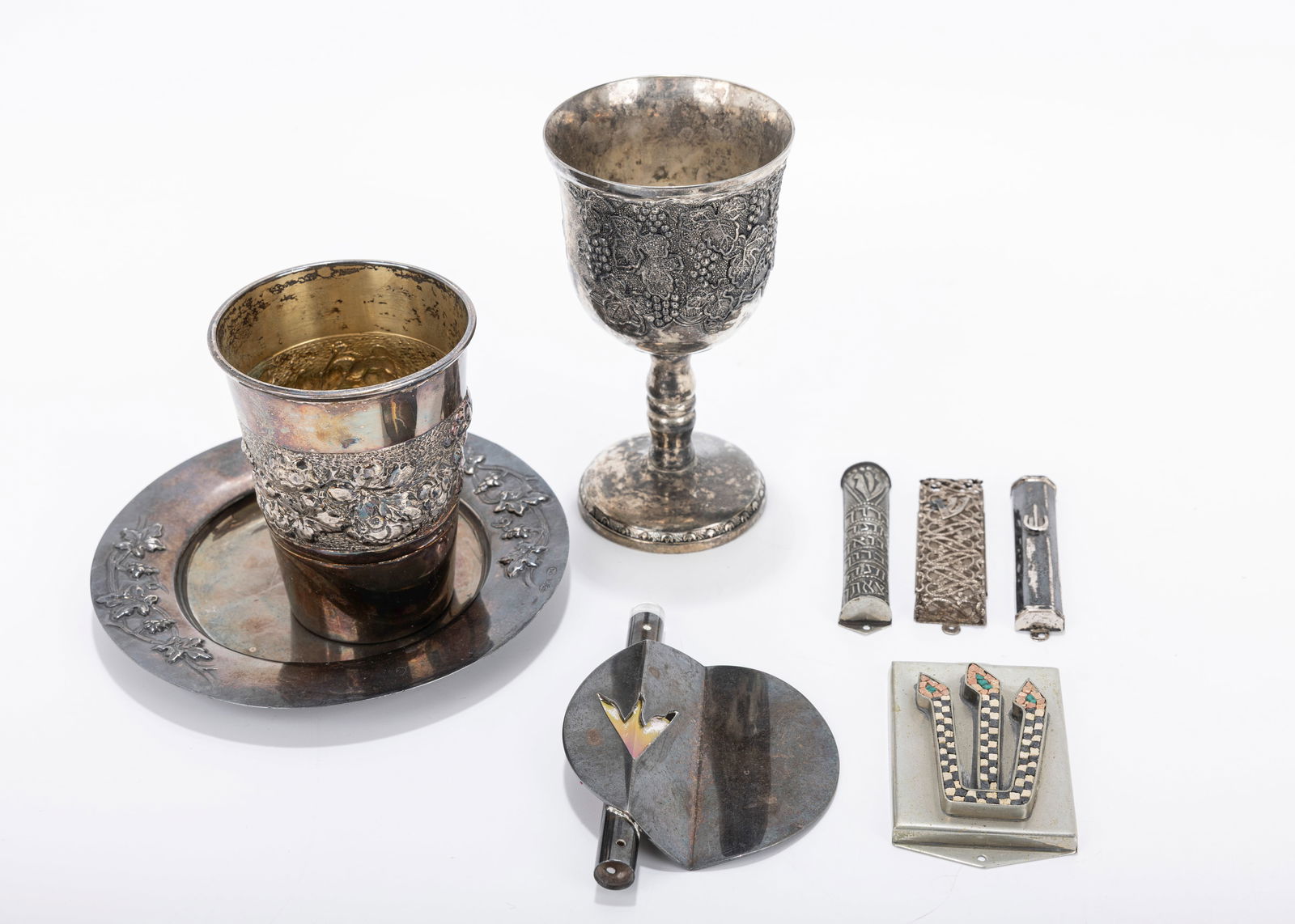 STERLING KIDDUSH CUP AND MEZUZAHS INCLUDING ARIE OFIR: Including a large sterling silver kiddush cup (3.7") and becher tray, as well as sterling silver mezuzah by Arie Ofir. Accompanied by a silverplated goblet and other mezuzah cases. Total silver weight