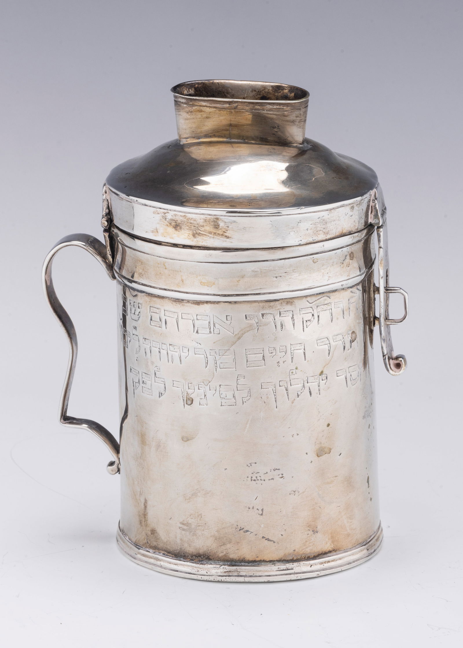 A RARE AND IMPORTANT SILVER CHARITY CONTAINER. Poland, c. 1790.: A RARE AND IMPORTANT SILVER CHARITY CONTAINER. Poland, c. 1790. Canister form with handle and hasp lock. Engraved in Hebrew: “THIS WAS MADE BY THE ORDER OF THE ALUFIM (COMMUNITY MEMBERS IN CHARGE) A