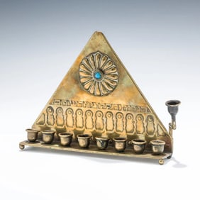 AN EARLY BRASS BEZALEL HANUKKAH LAMP. Jerusalem, c. 1910. Triangular in form.