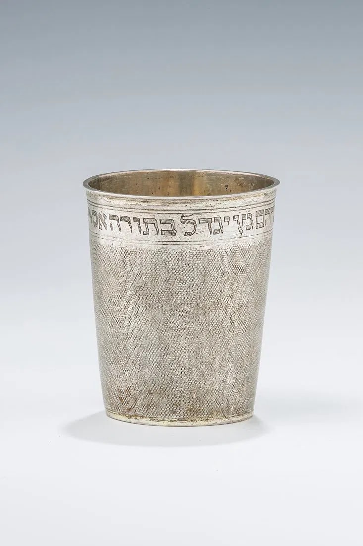 AN EARLY SILVER KIDDUSH BEAKER. Nuremberg, 17th century.: Sharkskin finish. Maker's mark TR and engraved on the bottom with two initials and date of 1673. Later inscribed in Hebrew: Jonathan a kind man son of the righteous Rabbi Abraham Getz. May he be raise