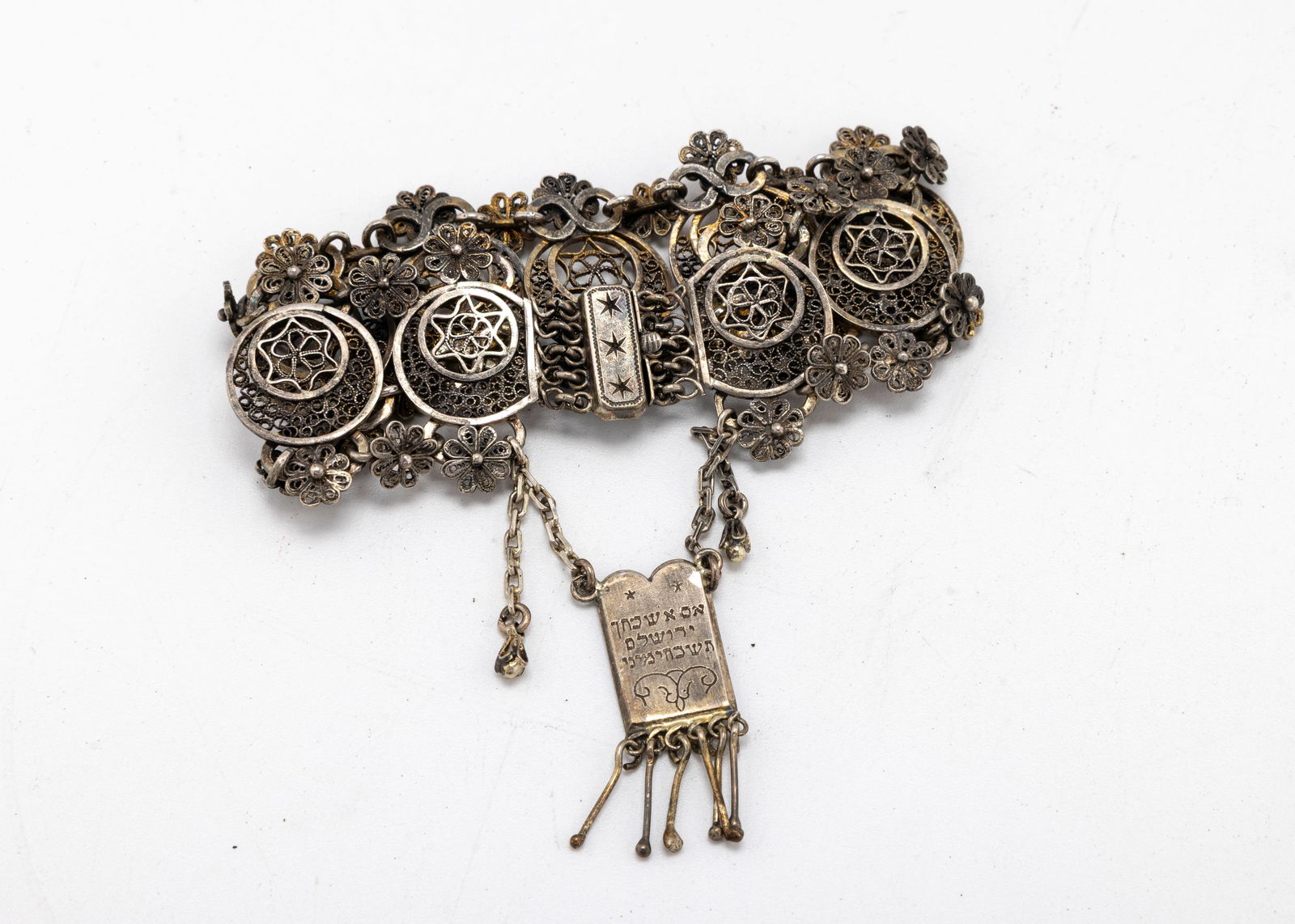 A MAGNIFCIENT STERLING FILIGREE BRACELET BY THE BEZALEL SCHOOL. Jerusalem, c. 1919.: Consisting of 14 circular filigree plaques, each with a Jewish star. Engraved Decalogue shaped plaque indicating Bezalel on one side and "IF I FORGET THE O JERUSALEM, I WILL FORGET MY RIGHT ARM. Signe