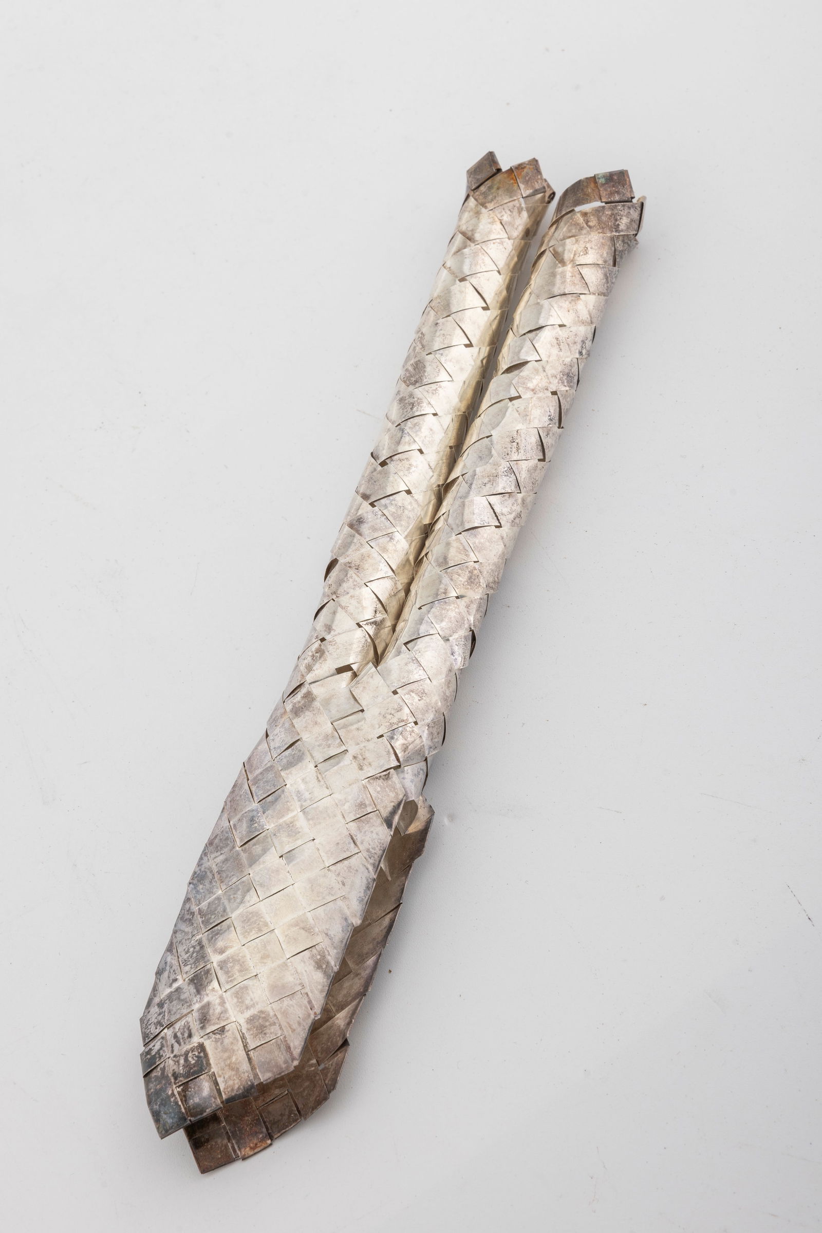 A STERLING SILVER LULAV HOLDER BY NETAFIM.: Israel, C. 1990. Woven, like a regular lulav holder, but instead of palm, sterling silver is used. 8.5" long and 1.50 ozt.