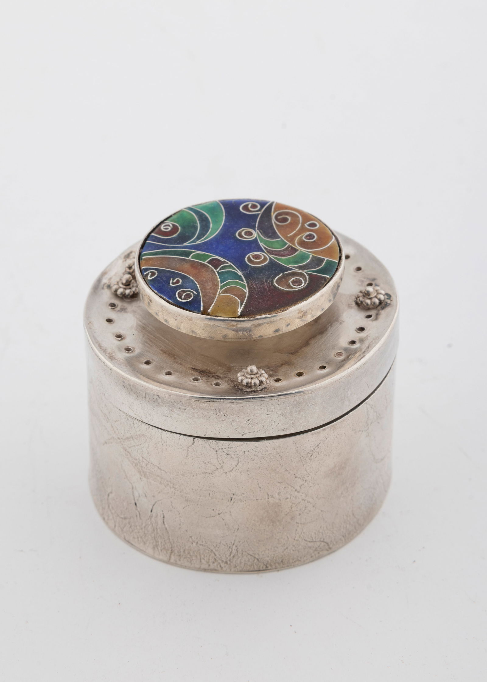 A STERLING SILVER SPICE CONTAINER BY ILANA RAPPAPORT. American, c. 1990: Circular in form. the upper portion pierces and decorated with an enamel mosiac. 2.4" wide and 153.8 grams