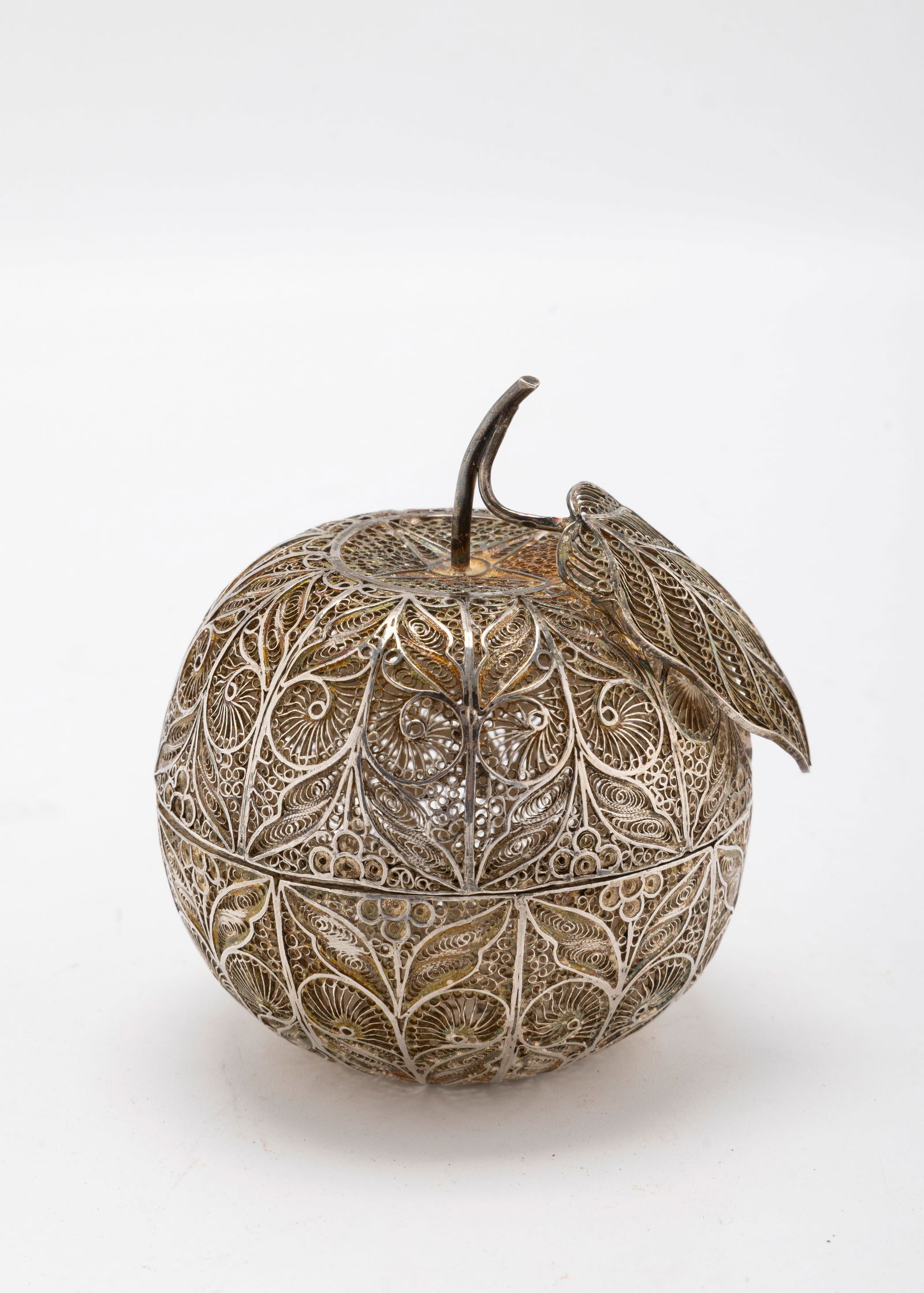 A SILVER FILIGREE SPICE CONTAINER IN THE SHAPE OF AN APPLE: Continental c. 1900Shaped as an apple. Completely made out of filigree silver. Opens into two pieces. 87.4 grams. 3.5" tall.