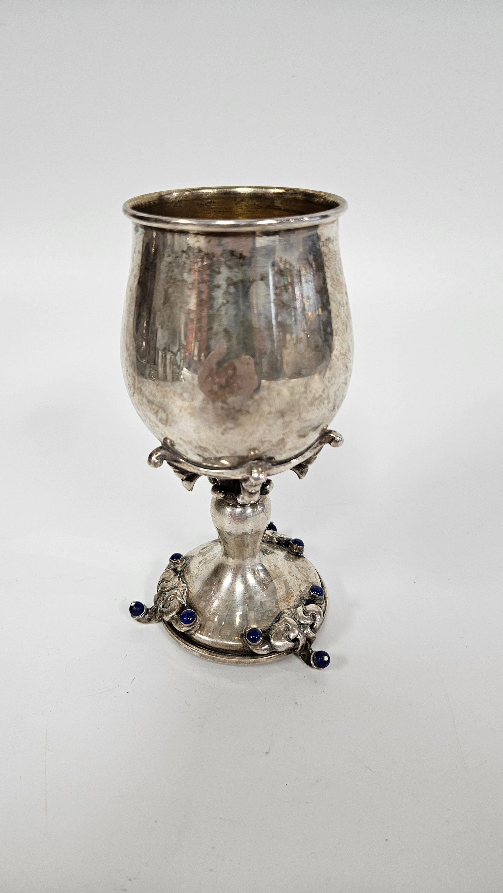 A LARGE HAND MADE STERLING KIDDUSH CUP BY DABBAH: Israel, c. 1990. On three feet. Decorated with nine lapis applications. Handsigned by Dabbah. 5.4" tall and 5.5 ozt.
