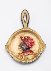 A CAST IRON SKILLET WITH AN AFRICAN AMERICAN WOMAN. American, c. 1900