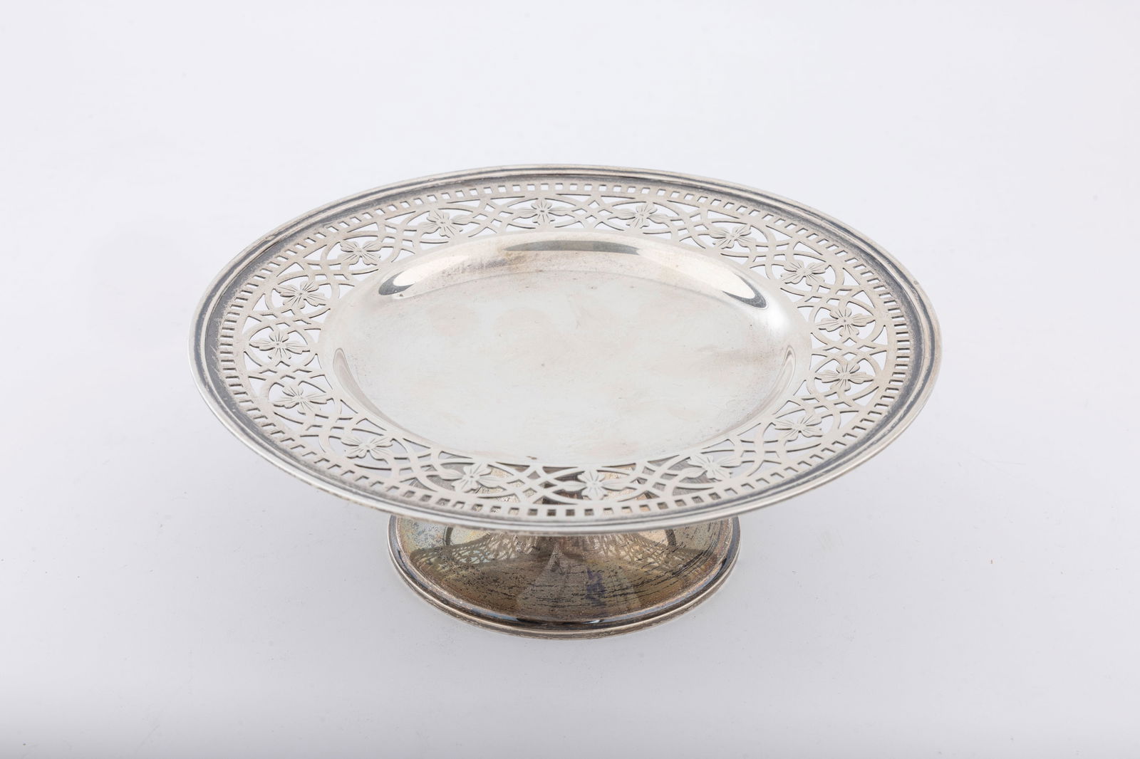 A STERLING SILVER FOOTED TAZZA BY TIFFANY AND COMPANY. New York, c. 1950: On a domed base that supports a lattice work upper portion. 172.7 grams, 6.2" wide and 2" tall.